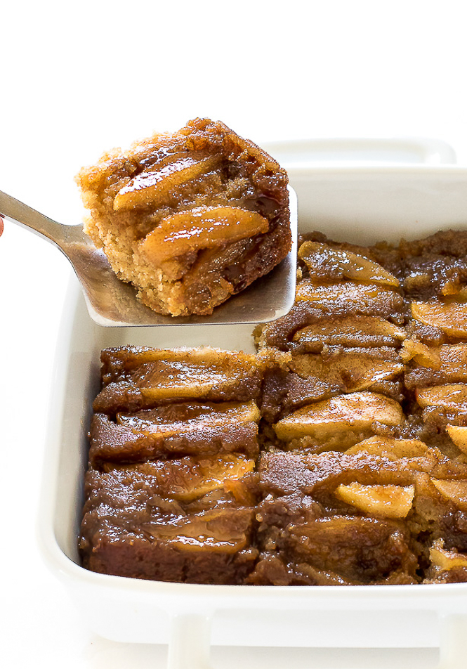 serving up slices of apple upside down cake on a silver spatula